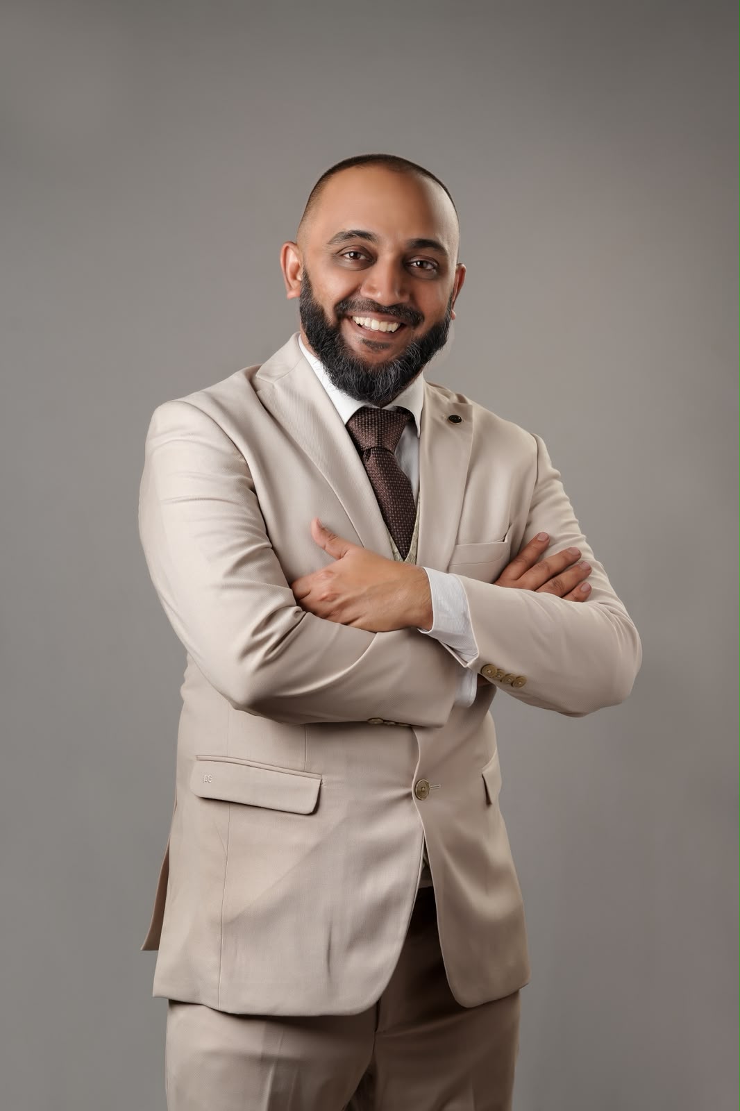 Rafeeq Cherusseri in a cream suit, arms folded